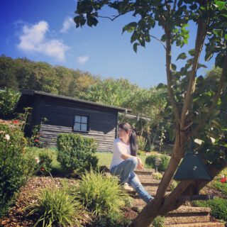 Alexandra sitzt im Garten auf der Treppe