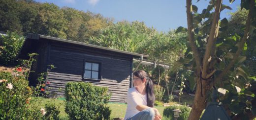 Alexandra sitzt im Garten auf der Treppe